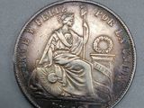 une vieille pièce de monnaie sur laquelle est assise une femme
