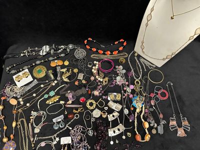 many different necklaces and bracelets laid out on a table