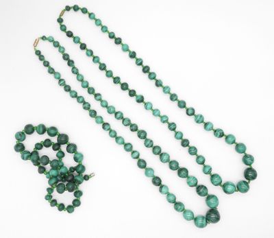 a close up of a necklace and a pair of earrings on a white surface