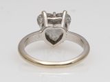 a close up of a ring with a heart shaped diamond on it