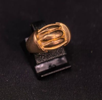 gros plan d'une bague en or sur une surface noire