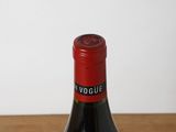a bottle of wine sitting on a table next to a glass of wine