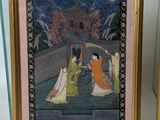 two framed paintings of women in traditional dress sitting on a ledge