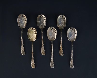 six silver spoons are lined up on a black surface