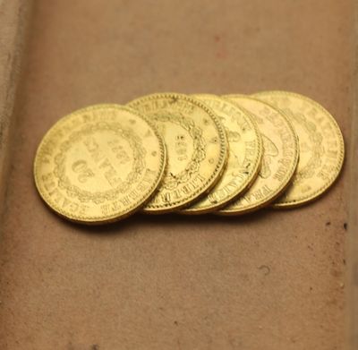 cinq pièces d'or posées sur une boîte en carton