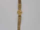 a close up of a gold wrist watch on a white surface