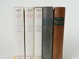 three books sitting on top of each other on a white surface