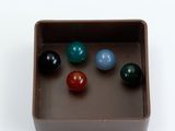 a chocolate box with six different colored marbles in it