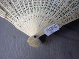 a white fan with writing on it sitting on a table