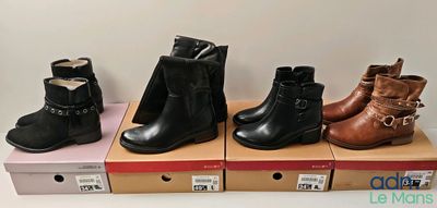 Quatre paires de bottes pour femmes sont exposées sur des boîtes