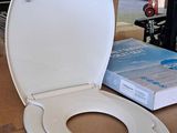 a toilet that is sitting on the floor next to a book
