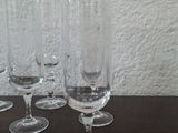 several empty wine glasses are lined up on a wooden table
