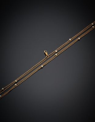 un bracelet en chaîne d'or orné de perles et muni d'un fermoir en or