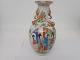a vase with a painting on it sitting on a table