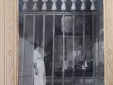 a black and white photo of a man standing in front of a window