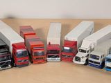 Plusieurs camions miniatures sont alignés en rang sur une table