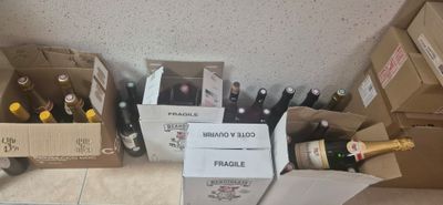 bottles of wine are lined up on the floor next to cardboard boxes