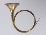 an antique brass french horn with a ring on top of it