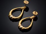 a pair of gold earrings on a black surface