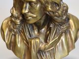 un buste antique en bronze représentant une femme aux cheveux longs et portant un foulard