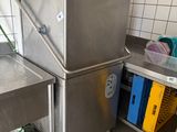 un évier en acier inoxydable dans une cuisine, à côté d'un meuble métallique