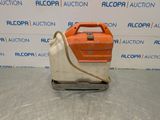 an orange and white machine sitting on top of a metal surface
