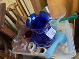un pichet en verre bleu posé sur un récipient en plastique