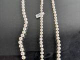 a close up of a white pearl necklace with a tag on it