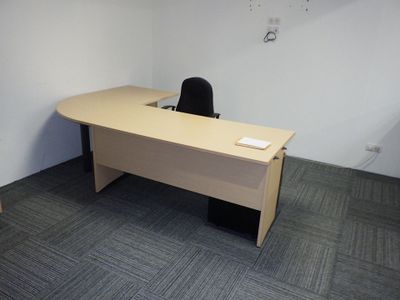 une photo d'un bureau vide avec un bureau et une chaise