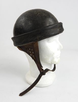 un vieux casque posé sur la tête d'un mannequin, sur une surface blanche