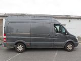 a grey van parked in a parking lot in front of a building