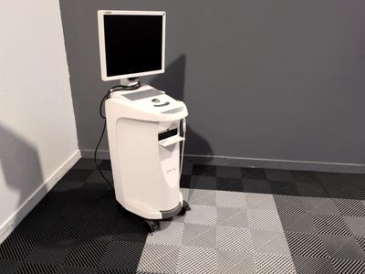une image représentant un ordinateur et un écran posé sur un support dans une pièce