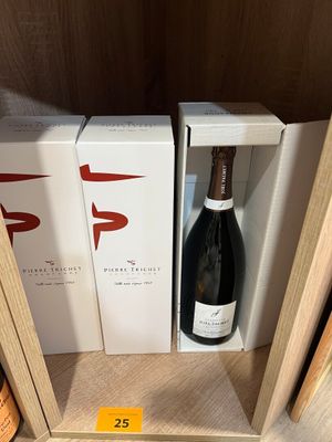 Deux bouteilles de vin sont posées sur une étagère dans un magasin.