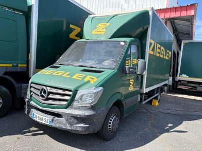 un camion vert garé devant un immeuble