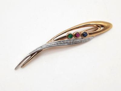 un gros plan sur une barrette dorée et argentée ornée de pierres multicolores