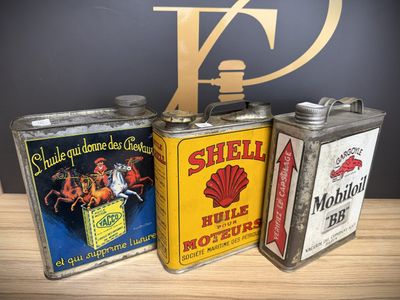 three vintage shell oil cans sitting on top of a wooden table