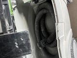 a white toilet with a black hose in the middle of it