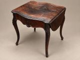 a small wooden table with a marble top and carved legs