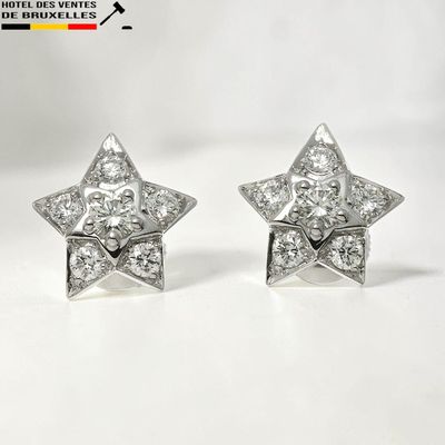 une paire de boucles d'oreilles en forme d'étoile en diamant sur fond blanc