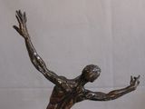 a bronze statue of a man holding a tennis racquet