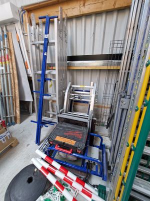 une pièce dans laquelle se trouvent une échelle, une étagère, une chaise et plusieurs autres objets