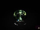 un gros plan d'une tourmaline verte posée sur une surface noire