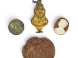 three pieces of gold and silver jewelry including a cameo, a cameo, and a cameo