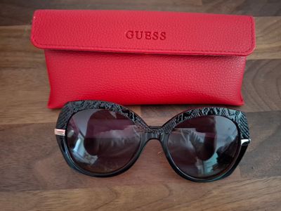 un gros plan sur une paire de lunettes de soleil dans un étui rouge