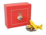 un petit avion miniature à côté d'une boîte rouge contenant des pièces de monnaie
