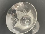 a wine glass with a design on it sitting on a table