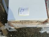 un réfrigérateur blanc posé sur une pile de cartons