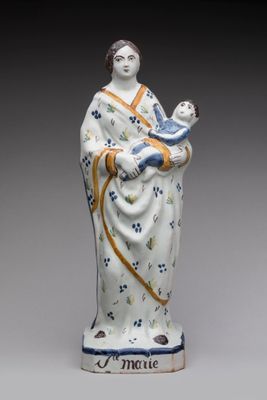 figurine d'une femme tenant un enfant dans ses bras