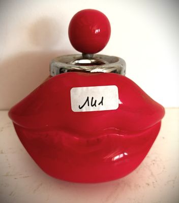 un récipient en forme de lèvre rouge sur lequel est apposée une étiquette nominative