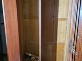 a wooden cabinet with a door open in a room